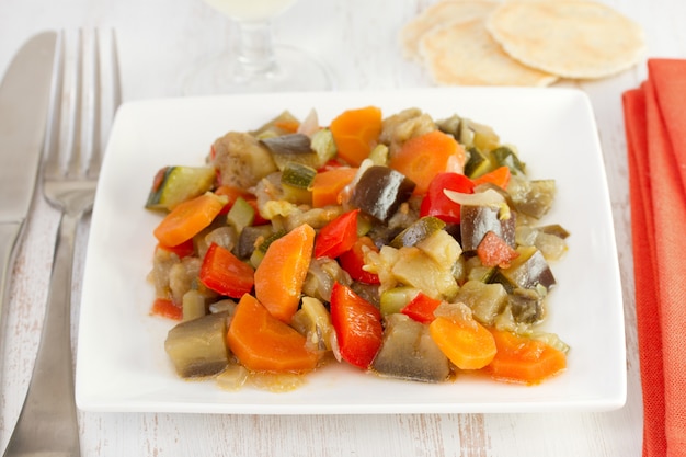 Boiled vegetables on the plate and fork with knife