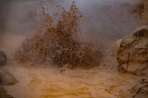 Photo boiling mud erupts from a pool at yellowstone national park mud pots