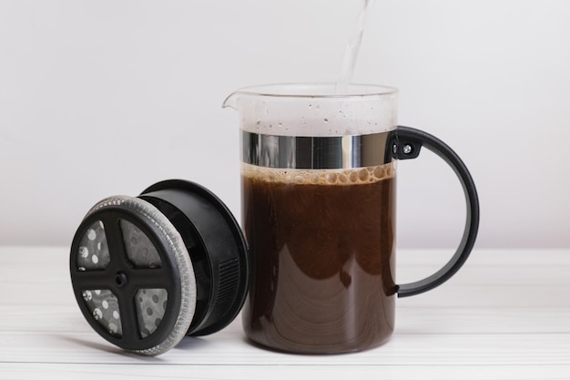 Boiling water is poured into a french press glass decanter