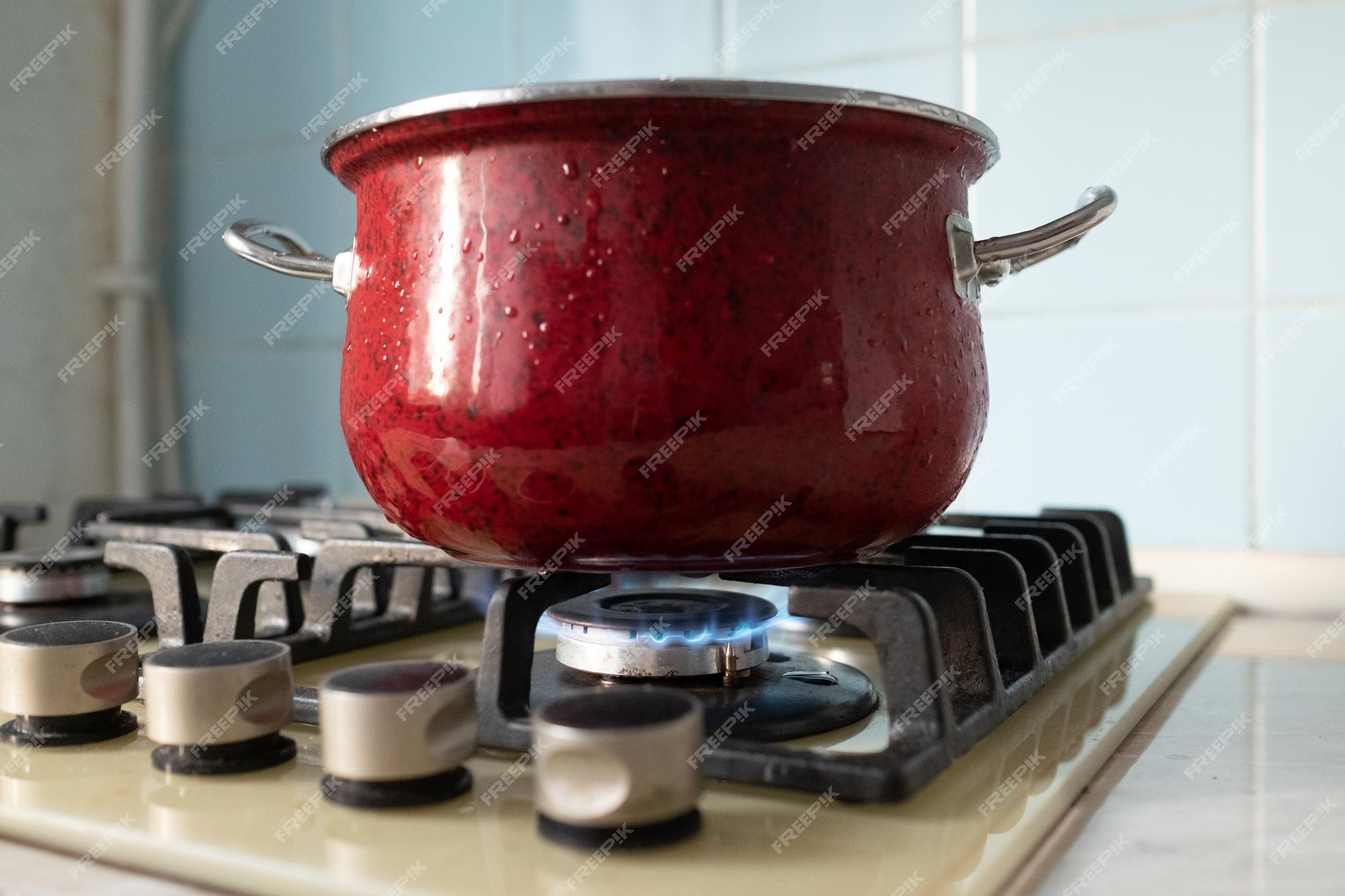 Premium Photo  Boiling water in ladle on blue flame burner steel pot on  gas burner