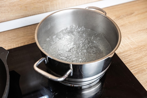 Acqua bollente in una casseruola su un fornello elettrico