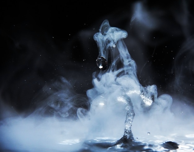 Photo boiling water splash with steam on black background