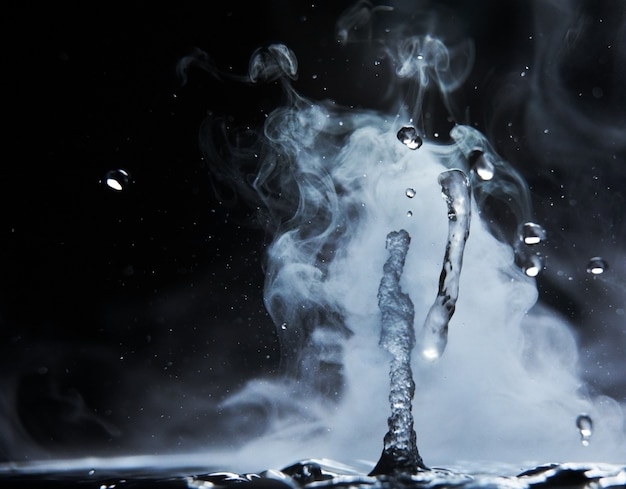 Boiling water splash with steam on black background