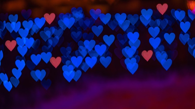 Premium Photo | Bokeh background with blue and red hearts on black  background. love concept. theme for valentine's day. high quality photo