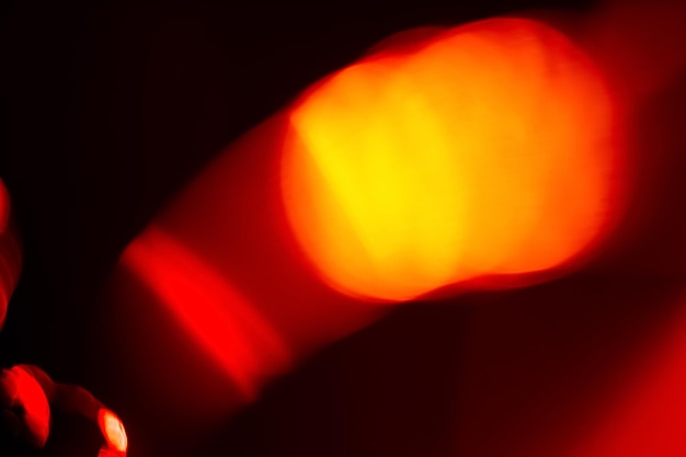 Bokeh licht Blur uitstraling Gloeiende vlekjes Intreepupil heldere neon rood oranje besmeurde cirkels op donkere abstracte achtergrond met kopie ruimte