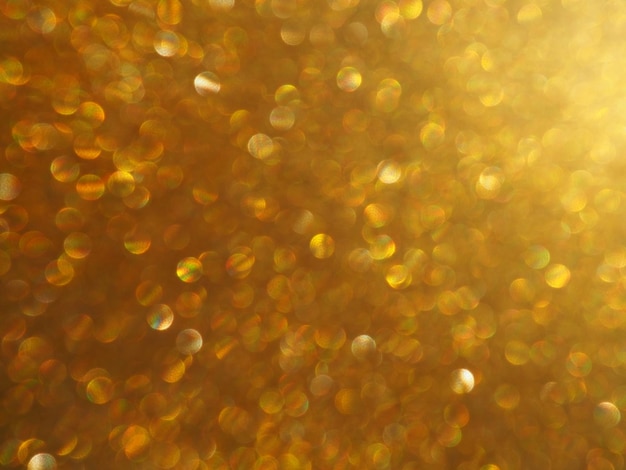 Bokeh licht van gouden glitters. Gouden glitter textuur achtergrond. Sprankelend glitter inpakpapier met pailletten en glitters. Feestelijke gouden bokeh en glitter. Mooie macroachtergrond.