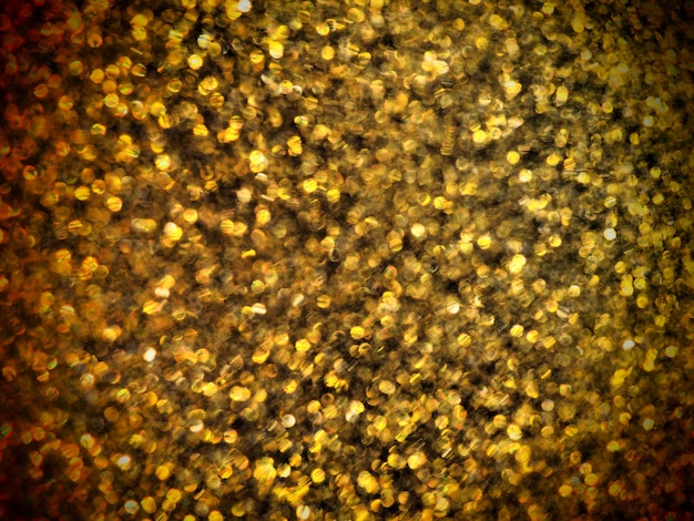 Foto bokeh licht van gouden glitters. gouden glitter textuur achtergrond. sprankelend glitter inpakpapier met pailletten en glitters. feestelijke gouden bokeh en glitter. mooie macroachtergrond.