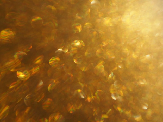 Bokeh light of gold glitters Golden glitter texture background Sparkling glitter wrapping paper with sequins and sparkles Festive golden bokeh and glitter Beautiful macro background