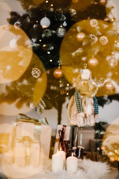 Bokeh Versierd kerstinterieur Kerstboom met geschenkdozen en kaarsen in een kamer Firtree versierd met slingers Decor Het concept van wintervakantie