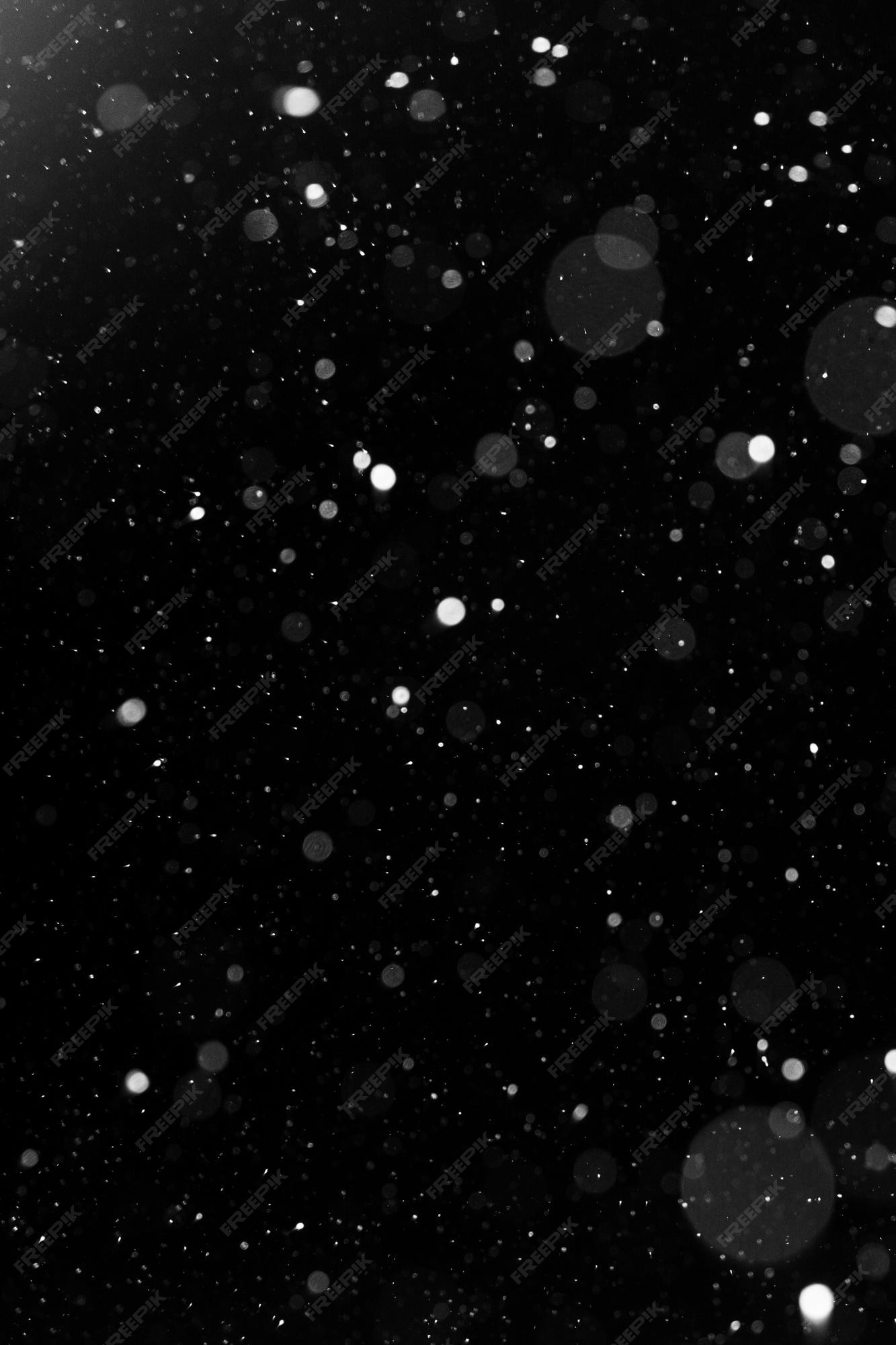 Premium Photo | A bokeh of white snow on a black background