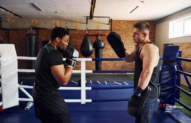 Boksen oefenen Afro-Amerikaanse man met blanke man heeft een trainingsdag in de sportschool