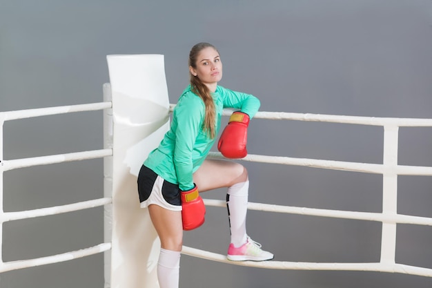 Boksende vrouw in groene sportkleding in de ring