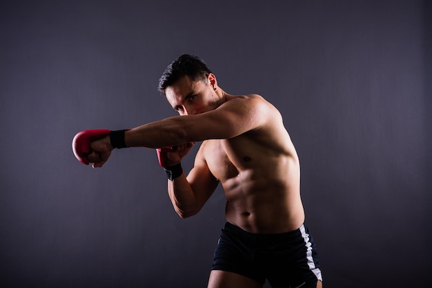 Bokshandschoenen man training in sport strijd uitdaging of mma competitie op studio achtergrond