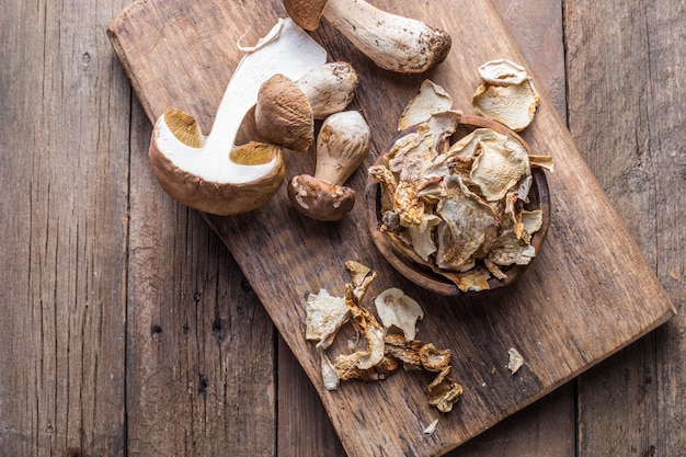 Foto set di funghi secchi selvatici boletus, su vecchio sfondo di tavolo in legno scuro