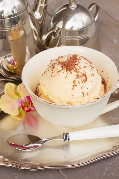 Bolletje vanille-ijs met chocolade geserveerd in beker