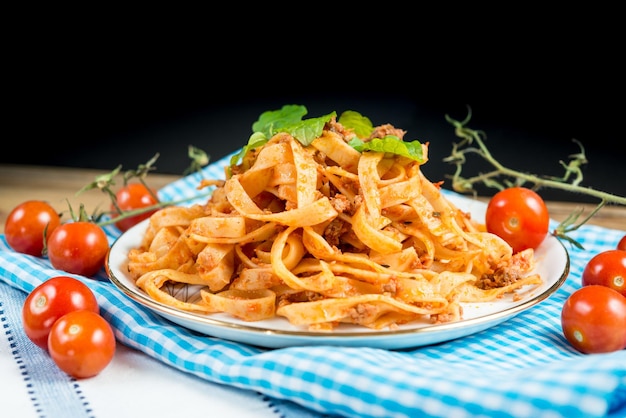 Bolognese op een bord tussen tomaten op stof boven de tafel.
