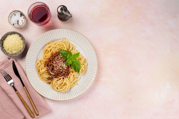 Bolognese spaghetti in een witte plaat op een lichtroze achtergrond Uitzicht van bovenaf