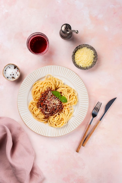 Bolognese spaghetti in een witte plaat op een lichtroze achtergrond Uitzicht van bovenaf