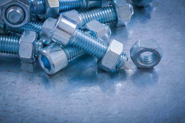 Bolts and nuts on scratched metallic background construction concept