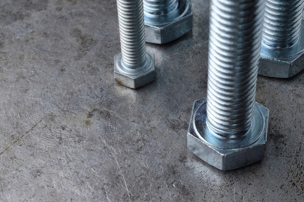 Bolts of various sizes laid out on a metal surface. assorted closeups.