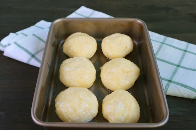 Bolvormig deeg in bakplaat voor het bakken van Braziliaans kaasbrood of Pao de Queijo