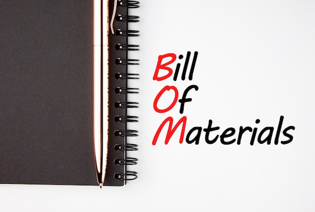 BOM bill of materials text on a white sheet with a notepad and pen Business concept