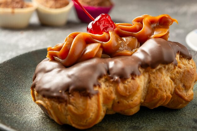 Photo bomba de doce de leite or eclair is a brazilian bakery shop sweet food dessert over marble table