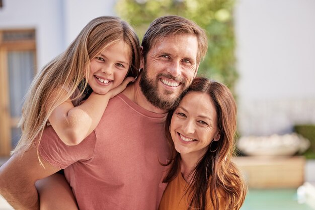 Bonding happy and parents with child in the garden of their family home for summer smile and relax Real estate peace and portrait of a girl kid with mother and father in the backyard of the house