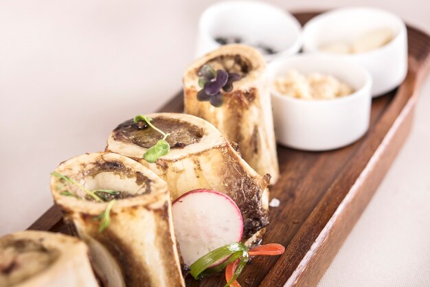 Bone marrow served with garlic, horseradish puree and black, pink and white salt