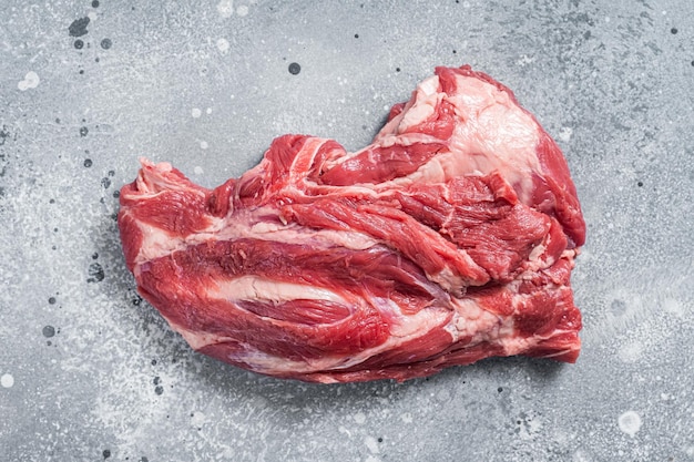 Carne cruda disossata del collo dell'agnello su una tavola del macellaio sfondo grigio. vista dall'alto.