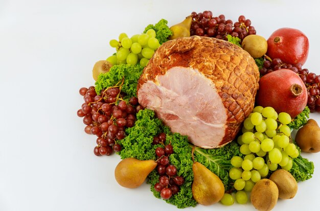 Boneless whole pork ham with fresh fruits. Healthy food. Easter meal.