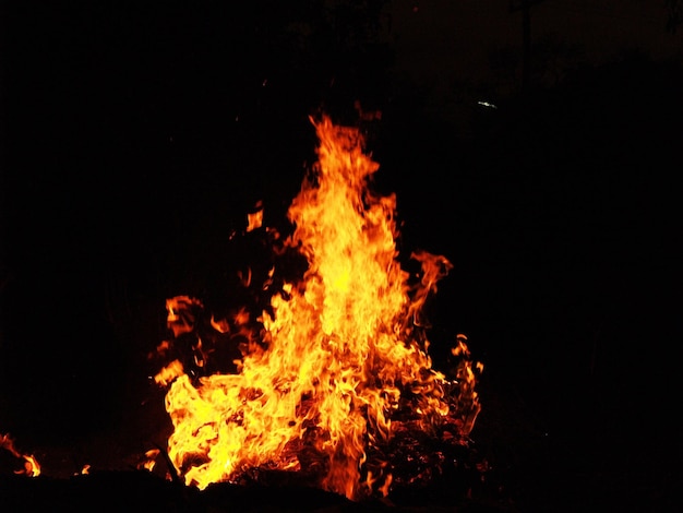 Foto un falò al buio con sopra la parola fuoco