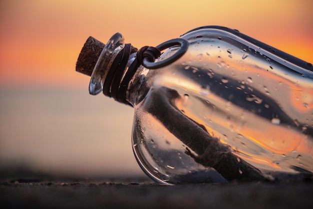 Boodschap in de fles tegen de ondergaande zon