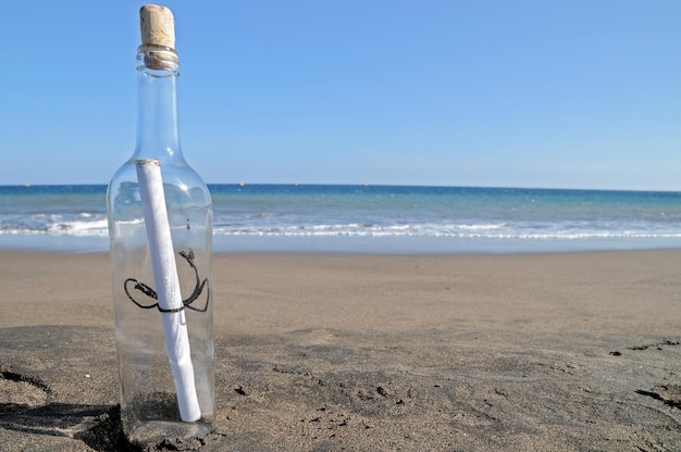 Boodschap in een flesje op een eenzaam strand