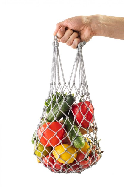 Boodschappentas mesh met gezonde groenten. Zero waste. Man hand met zak met mesh producten.