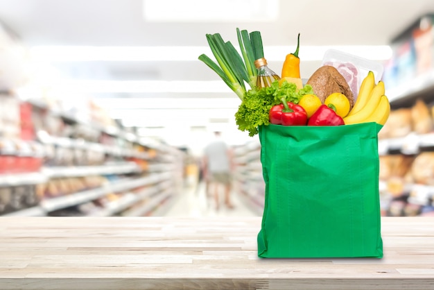 Boodschappentas met voedsel en boodschappen op de tafel in de supermarkt