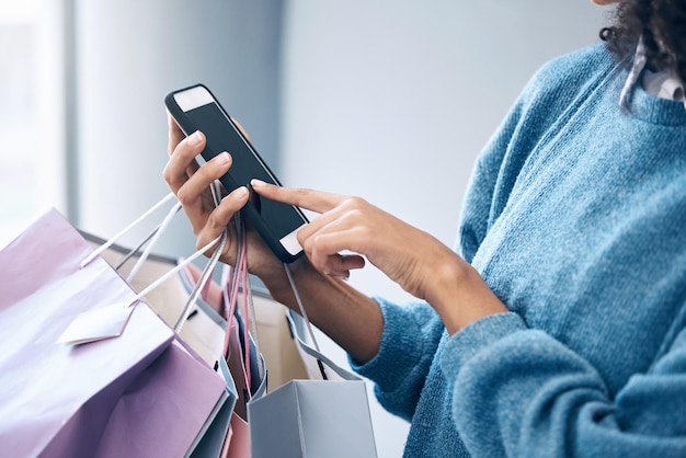 Boodschappentas zwarte vrouw of hand met telefoon in winkelcentrum voor korting modeverkoop of luxe merkwinkel Zoek of meisje op smartphone voor promocode sociale media of nieuws app online retailwebsite