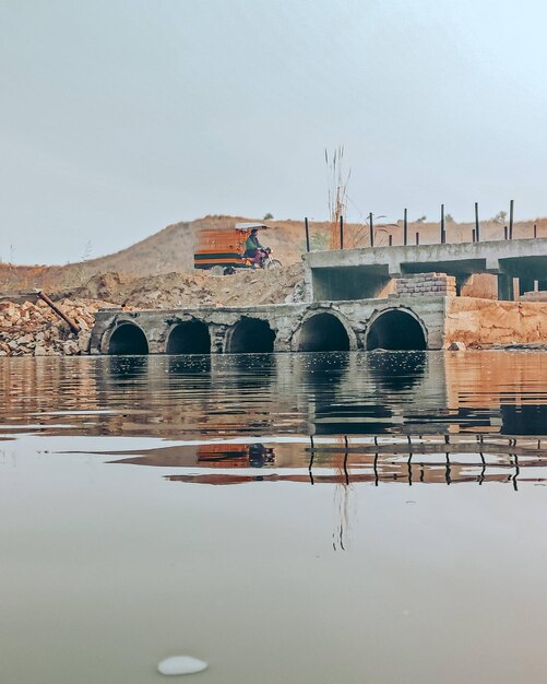 Foto boogbrug over rivier door gebouwen tegen de lucht