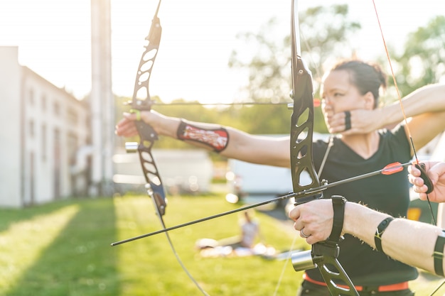 boogschieten competitie, vrouw die een pijl en boog voorbereidt om doelen te raken