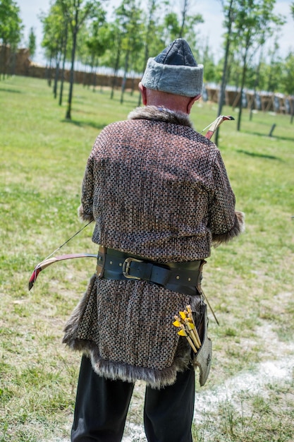 Boogschutter in traditionele kleding die een pijl schiet