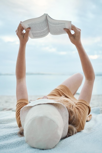 Book beach and woman reading on holiday for calm peace and travel by the ocean in Bali during summer Free relax and girl with novel on the tropical sand while on an island vacation in nature