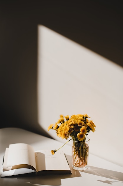 a book and a bunch of yellow dandelions