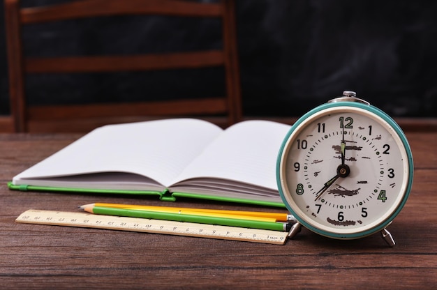 Book and clock on wooden table