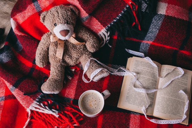 book and coffee cup on red plaid. autumn flat lay