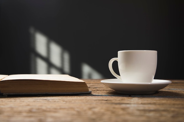 Book and a cup of coffee on a wooden table