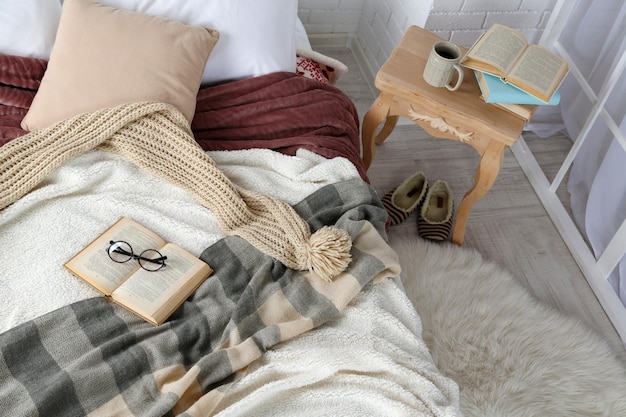 ベッドのクローズアップの本とメガネ