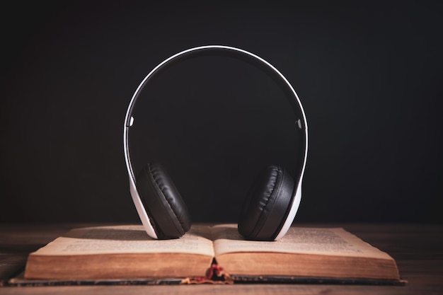 A book and headphones are on the table audiobook concept