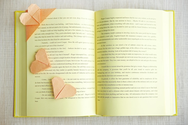 Book and heart shaped bookmarks on a light wooden background