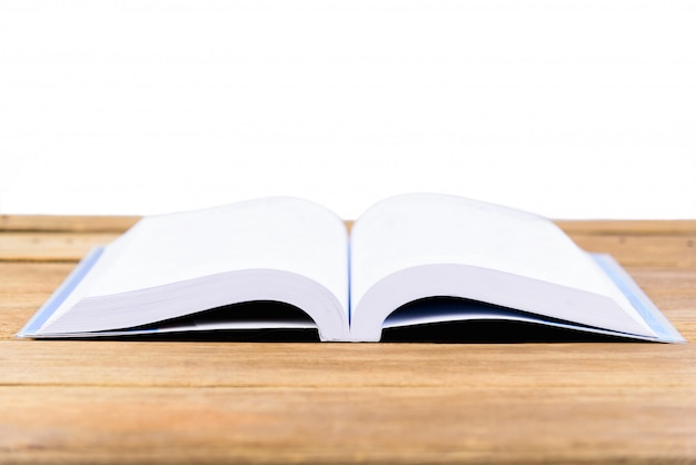 The book is open and placed on a wooden table 