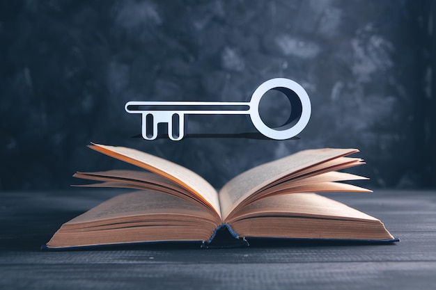 Book and key on gray background